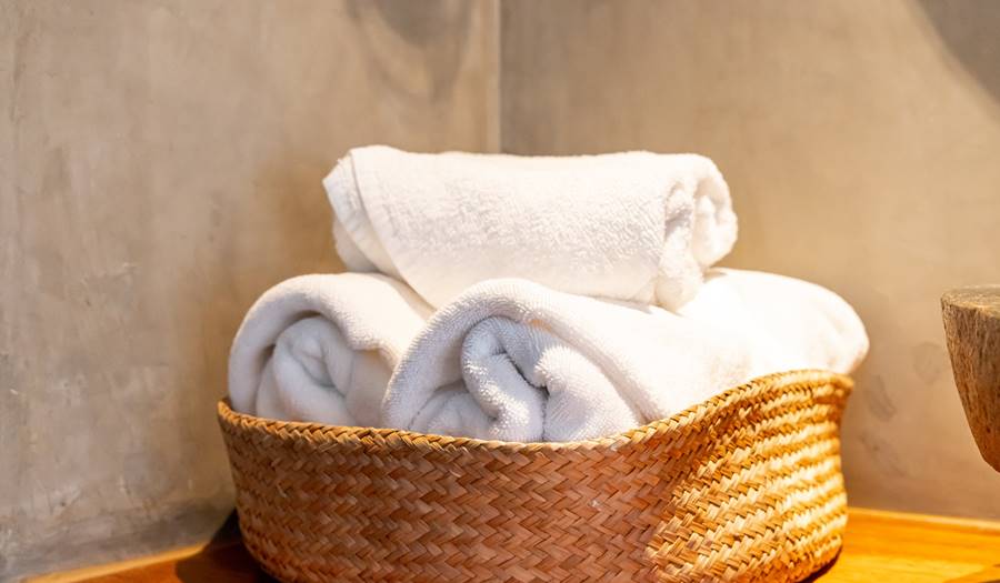 White Towel In Basket In Bathroom