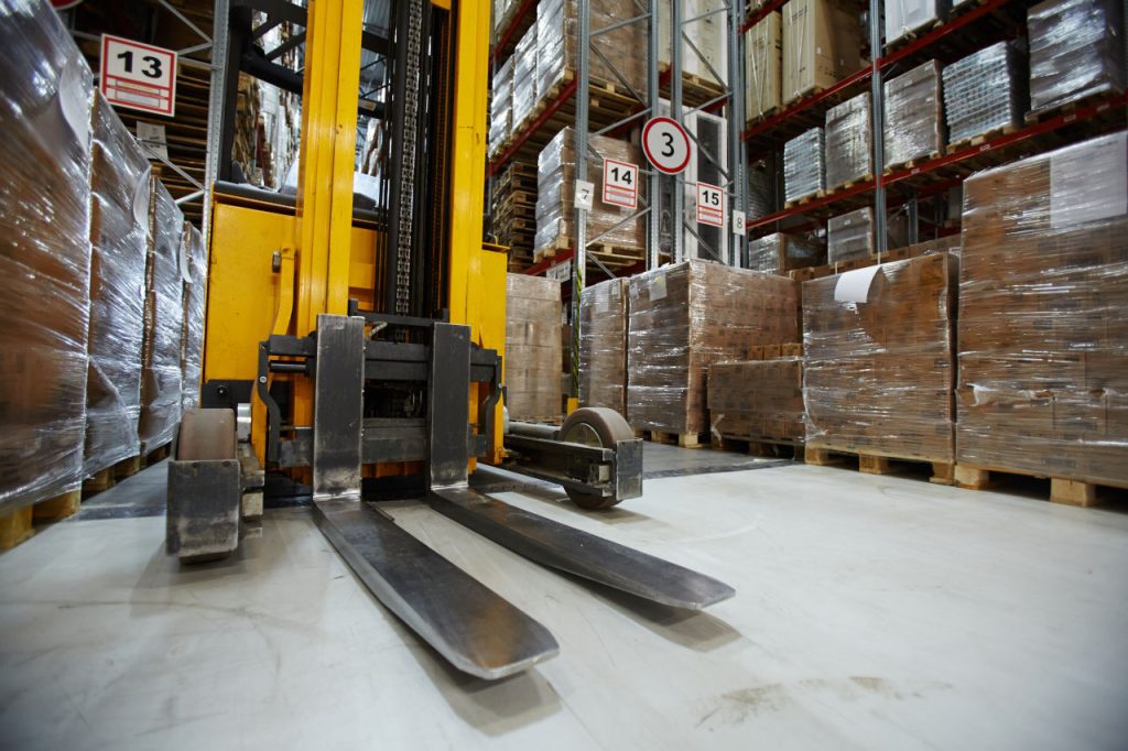 Forklift In Large Warehouse Of Products On Pallets