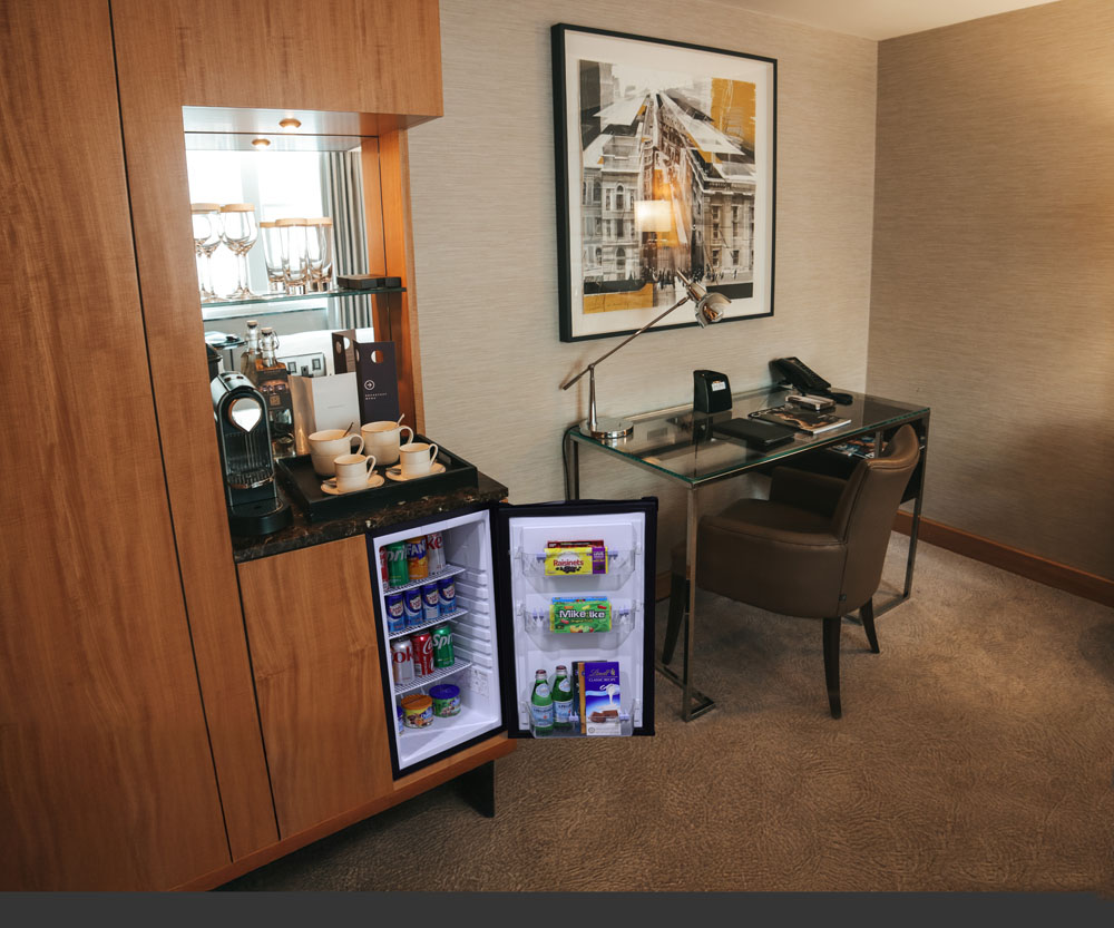 Hotel room amenities with the mini fridge open.